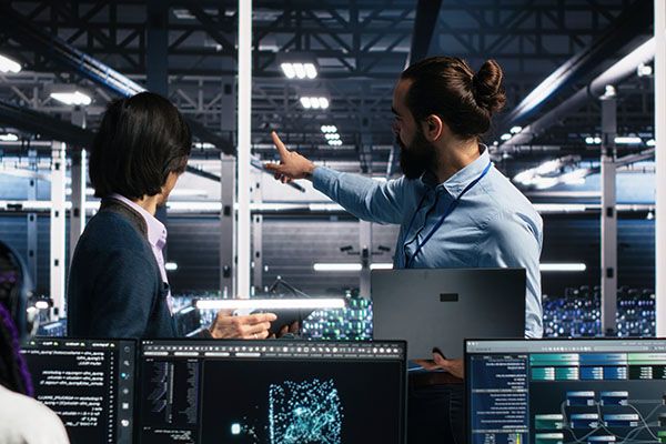IT colleagues collaborate in a data center while reviewing AI diagnostics and infrastructure performance.