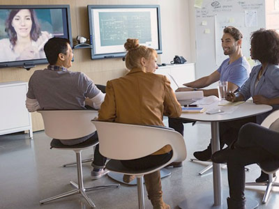 Work associates in a meeting room participating in a virtual call