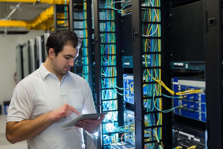 IT technician working on network servers and cables.