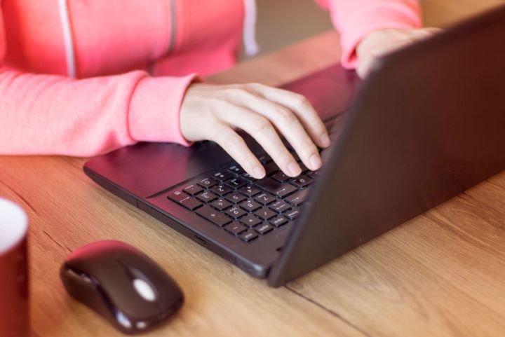 Hands of a girl writes on computer close up