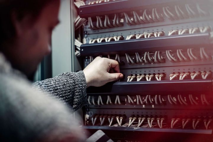 Young IT engineer standing near datacenter servers