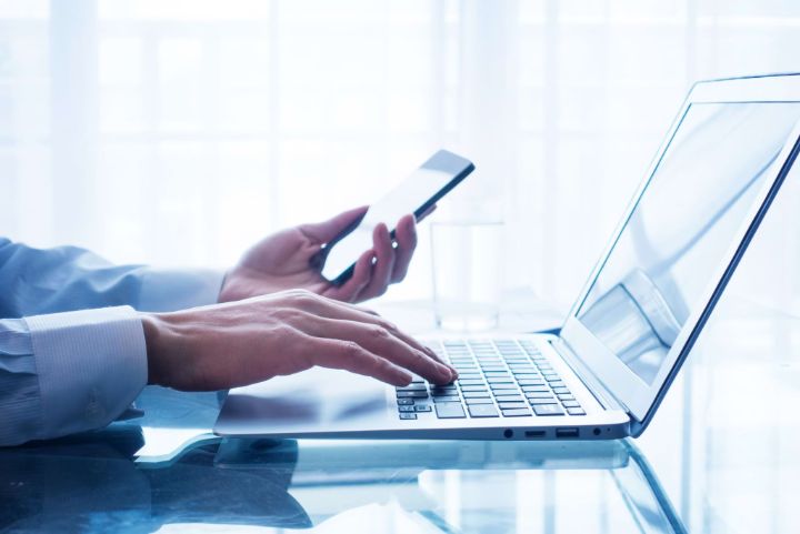 Businessman using mobile phone and laptop in office