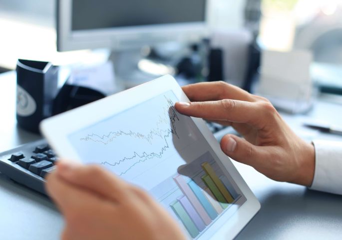 Business person analyzing financial statistics displayed on the tablet screen