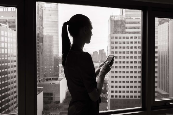 Woman using mobile smart phone in the office