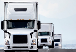 White carrier trucks on the road coming in a line representing asset tracking