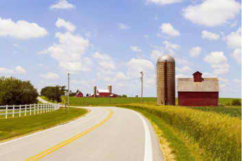 Pleasant road way leading to industries with green fields on the sides