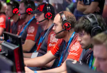 Online Gaming Support Team sitting with headsets in workplace and supporting gamers