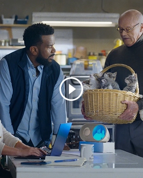 In the Wake Up with Craig office, Angela sits at a desk working on a laptop and Craig stands next to her. Creed approaches with a basket full of kittens.